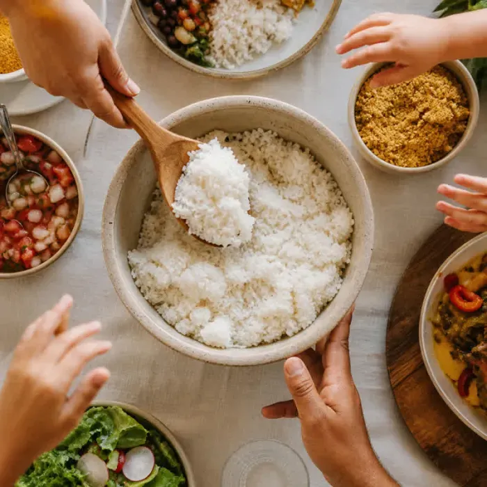 Arroz branco servido no centro de uma mesa de fam&iacute;lia